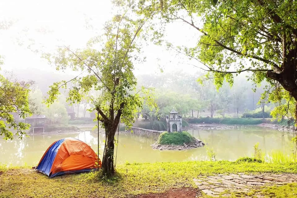 Chiếc lều cam bên hồ buổi sớm, xa xa là miếu nhỏ giữa nước